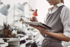 CRM system. The main female production manager working online with her digital tablet
